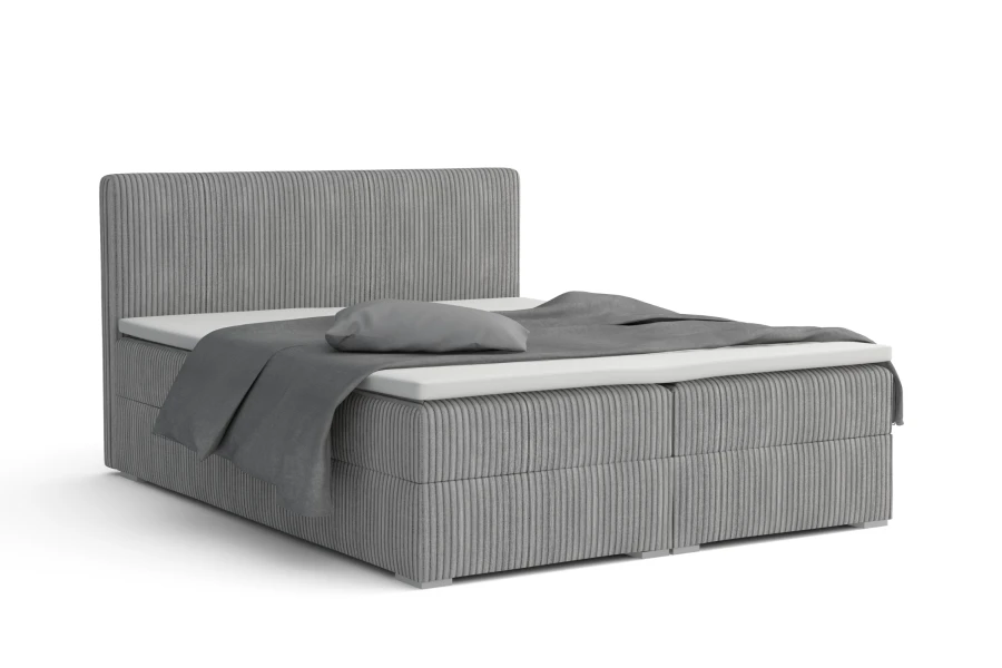 Modernes graues Boxspringbett mit Cord-Stoff auf weißem Hintergrund freigestellt.