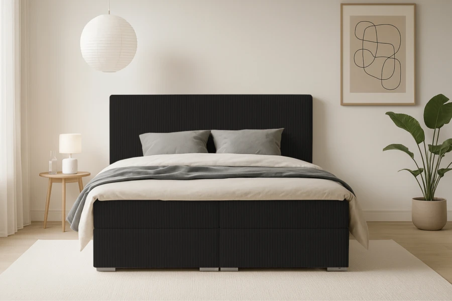 Frontale Ansicht eines schwarzen Boxspringbetts mit Rippenmuster.