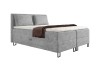 Graues Boxspringbett mit Stauraum und zwei Kissen vor weißem Hintergrund.