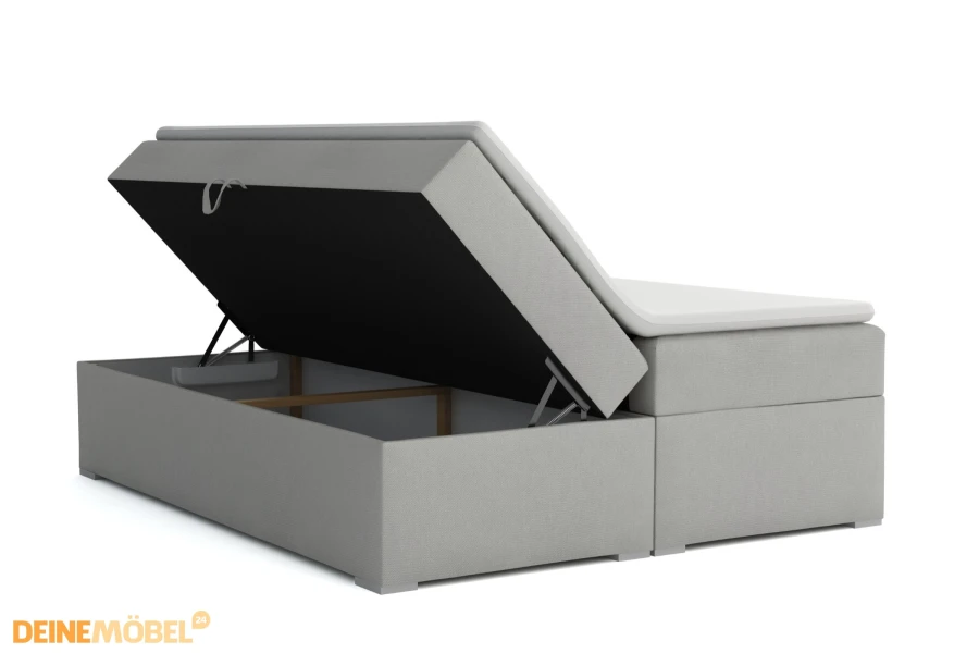 Graues Boxspringbett mit integriertem Bettkasten und Stauraum, seitlich geöffnet.