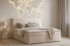 Gemütliches Schlafzimmer mit beige Boxspringbett und beleuchteter Weltkarte an der Wand.