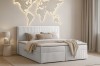 Modern eingerichtetes Schlafzimmer mit grauem Cord-Boxspringbett und Wanddekoration.