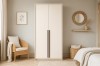 Moderner 2-türiger Kleiderschrank in Beige mit langen schwarzen Griffen im minimalistischen Schlafzimmer.