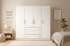 Großer weißer Kleiderschrank mit vier Türen, Schubladen und eleganten goldenen Griffen.