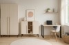 Einrichtung in Beige mit Kleiderschrank, passendem Sideboard und Schreibtisch.