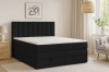 Modernes schwarzes Boxspringbett in einem hell eingerichteten Schlafzimmer mit Sessel und Deko.