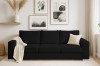 Schwarzes Cord-Sofa in gemütlich eingerichtetem Wohnzimmer mit Wandbildern.