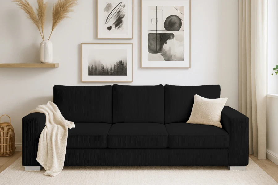 Schwarzes Cord-Sofa im modern eingerichteten Wohnzimmer mit Wandbildern und Dekoration.