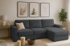 Modernes dunkelgraues Ecksofa in einem minimalistisch gestalteten Wohnzimmer mit Wandbildern und Pflanzen.