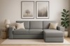 Dunkelgraues Ecksofa in stilvollem Wohnzimmer-Ambiente mit Lampe und Zimmerpflanze.