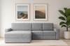Modernes graues Ecksofa im hellen Wohnzimmer mit Wandbildern und großer Pflanze.