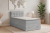 Graues Einzel-Boxspringbett in Cord-Optik im hellen Schlafzimmer-Ambiente.
