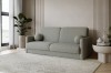 Modernes graues Bouclé-Sofa in einem hellen, minimalistischen Wohnzimmer mit Pflanzen.