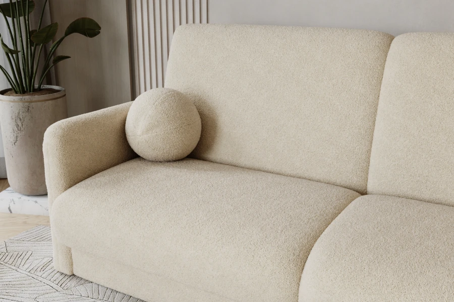 Detailansicht eines beigen Bouclé-Sofas mit rundem Dekokissen und weicher Textur.