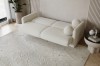 Ausgezogenes beiges Schlafsofa aus Bouclé-Stoff in gemütlicher Wohnzimmer-Umgebung.