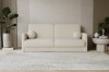 Beiges Bouclé-Sofa in modernem Wohnzimmer mit runden Zierkissen und hellem Teppich.