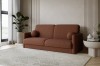 Rostbraunes Bouclé-Sofa in minimalistischem Interieur mit großer Zimmerpflanze.