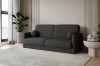 Dunkelgraues Bouclé-Sofa mit runden Kissen in modernem Wohnzimmer auf beigem Teppich.