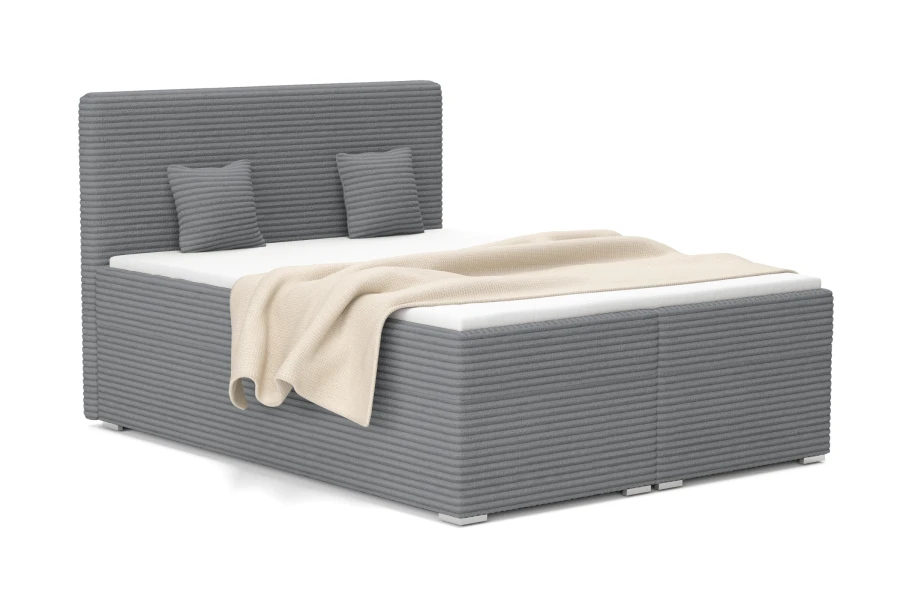 Graues Boxspringbett in moderner Cord-Optik mit passenden Kissen und Decke.