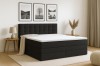 Modernes anthrazitfarbenes Boxspringbett im Schlafzimmer-Setting mit stilvoller Dekoration.