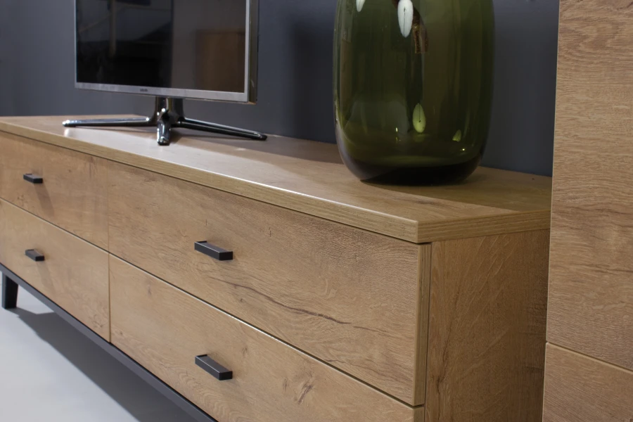 Modernes TV-Lowboard Liam in Eichenoptik mit schwarzen Metallgriffen und Deko-Vase.