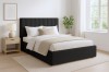 Modernes Schlafzimmer-Design mit schwarzem Polsterbett und heller Deko.