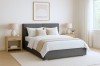 Modernes Schlafzimmer-Set mit dunkelgrauem Bett und warmer, heller Dekoration.