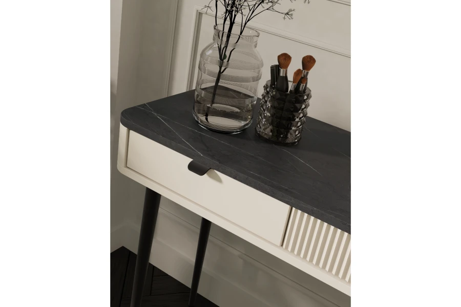 Detailansicht einer Konsole mit dunkler Platte in Marmor-Optik und geriffelter Front.