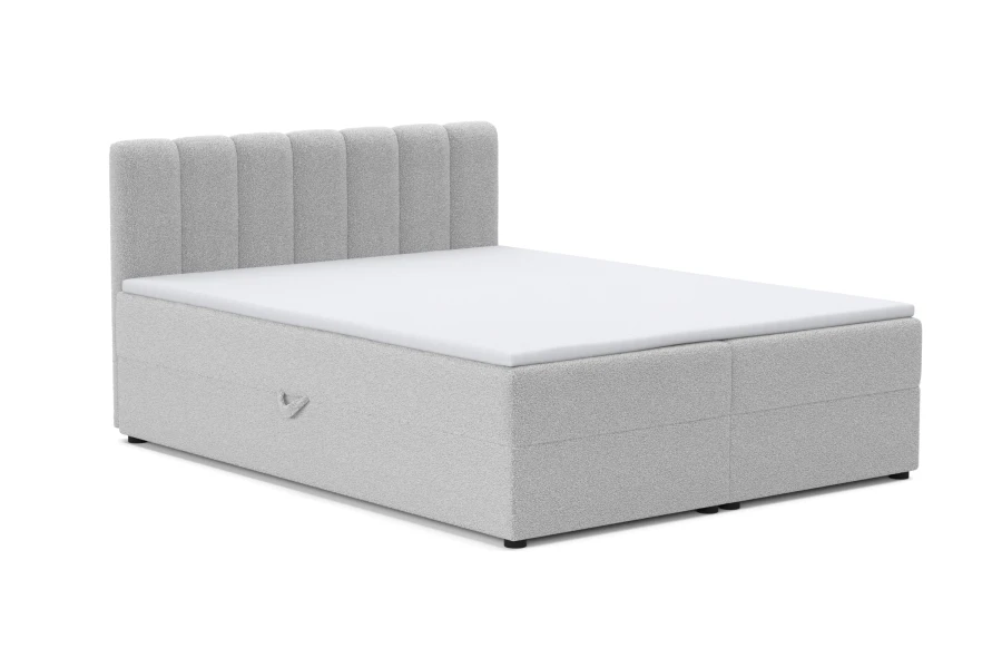 Hellgraues Boxspringbett aus Bouclé-Stoff mit modernem, gestepptem Kopfteil auf weißem Hintergrund.