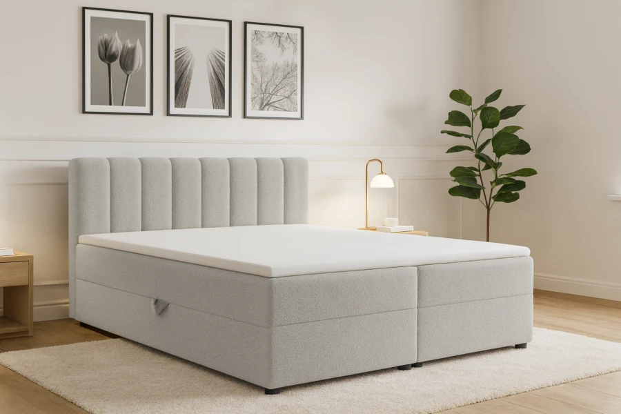 Stilvolles Schlafzimmer mit hellgrauem Boxspringbett, Zimmerpflanze und minimalistischer Wandkunst.