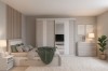 Komplettes Schlafzimmer-Set in Naturtönen mit großem Kleiderschrank, Kommode und Zimmerpflanze.