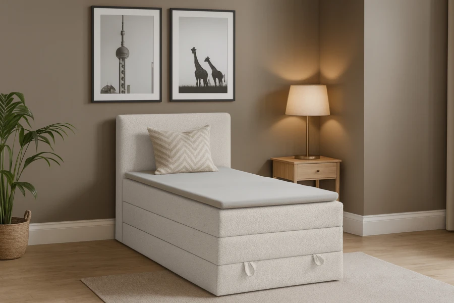 Beiges Boxspringbett im Schlafzimmer-Ambiente mit Lampe und Zimmerpflanze