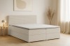 Helles Schlafzimmer mit modernem Boxspringbett in Cord-Optik.
