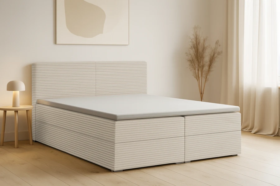 Helles Schlafzimmer mit modernem Boxspringbett in Cord-Optik.