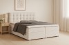 Beige Boxspringbett mit gestepptem Kopfteil und gestreiftem Stoff in modernem Schlafzimmer.