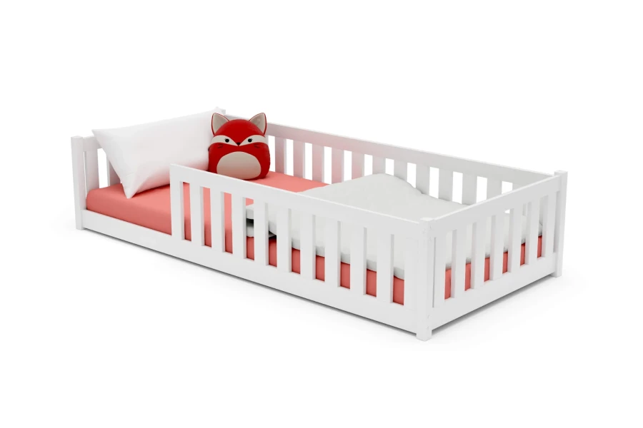 Weißes Kinderbett mit Rausfallschutz, rosa Matratze und rotem Fuchs-Kissen.