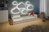 Kinderzimmer mit beleuchteter Wolken-Wanddekoration und weißem Kinderbett.