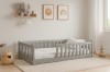 Graues Kinderbett aus Massivholz mit Rausfallschutz in skandinavischem Kinderzimmer Design.
