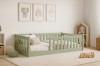 Salbeigrünes Kinderbett mit Rausfallschutz in einem hellen, modern dekorierten Kinderzimmer.