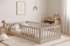 Gemütliches Kinderzimmer mit beigem Kinderbett aus Holz inklusive Rausfallschutz im skandinavischen Design.