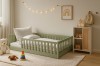 Eingerichtetes Kinderzimmer mit grünem Holzbett, Teppich und Spielzeug