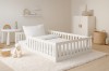 Modernes weißes Bodenbett für Kinder in gemütlicher Kinderzimmer-Umgebung mit Kuscheltieren.
