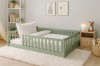 Eingerichtetes Kinderzimmer mit salbeigrünem Bodenbett und Teppich.