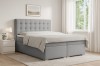 Hellgraues Boxspringbett im modernen Schlafzimmer-Design mit viel Tageslicht.