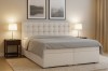 Modernes Boxspringbett in Beige mit gepolstertem Kopfteil in gemütlicher Schlafzimmer-Optik.