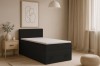 Modernes schwarzes Boxspringbett in einem hell eingerichteten Schlafzimmer.