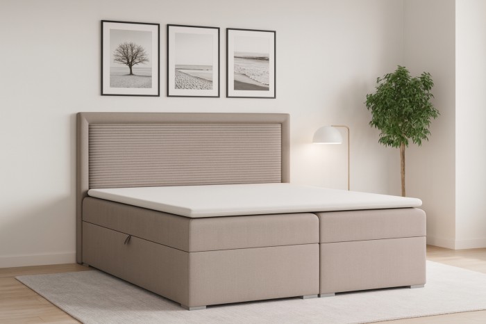 Modern boxspringbed in beige met geribbeld hoofdbord in een lichte slaapkamer.