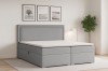 Modernes Boxspringbett in Hellgrau im minimalistischen Schlafzimmer mit Dekoration.