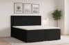 Modernes schwarzes Boxspringbett mit geriffeltem Kopfteil und weißem Topper in hellem Schlafzimmer.