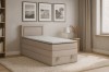 Beiges Boxspringbett im Schlafzimmer mit Wandbildern und Teppich.